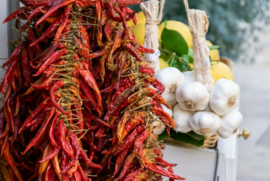 Colorful strings of dried chili peppers and garlic on display at the weekly market Santa Maria del Camí in Mallorca – a traditional and spicy Mediterranean market highlight.
