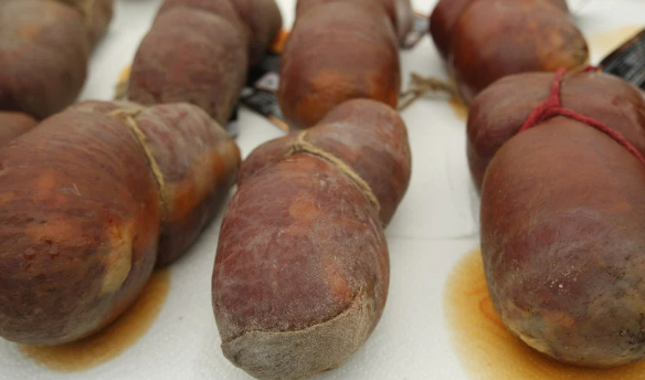 Traditional Mallorcan sobrasada sausage on sale at the weekly market Santa Maria del Camí – an iconic regional delicacy made with paprika and cured pork.