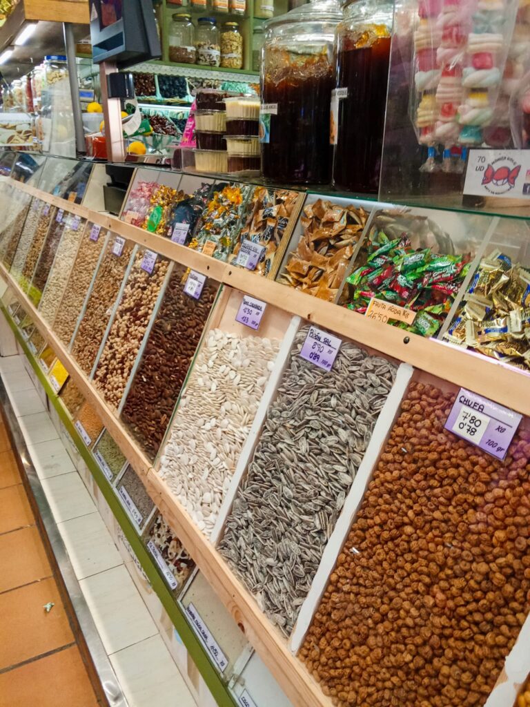 Bulk bins filled with legumes, seeds, and nuts inside the market.