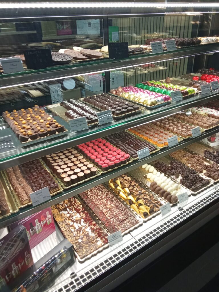 Chocolate truffles and assorted sweets in a refrigerated display case.