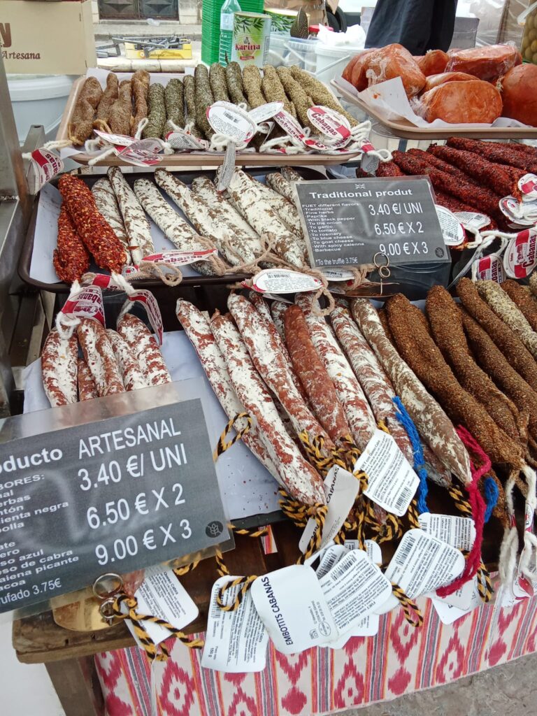 A stall selling a variety of artisanal sausages and cured meats, showcasing authentic Mallorcan flavors at the Binissalem market.