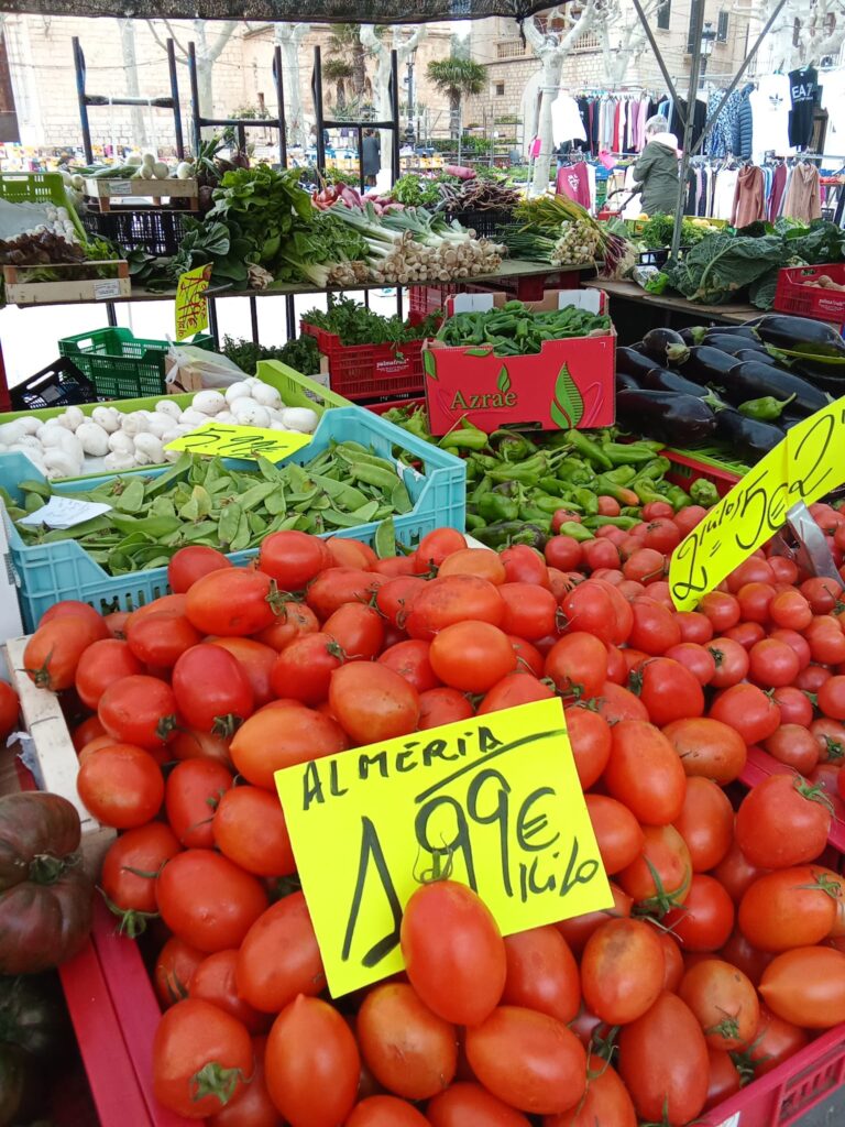 Fresh, locally grown tomatoes, beans, and vegetables on display at the Binissalem market, offering an authentic taste of Mallorca.
