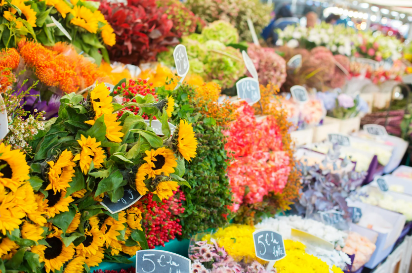 Flower market stall in Porto Cristo Mallorca with colorful seasonal flowers and price tags.