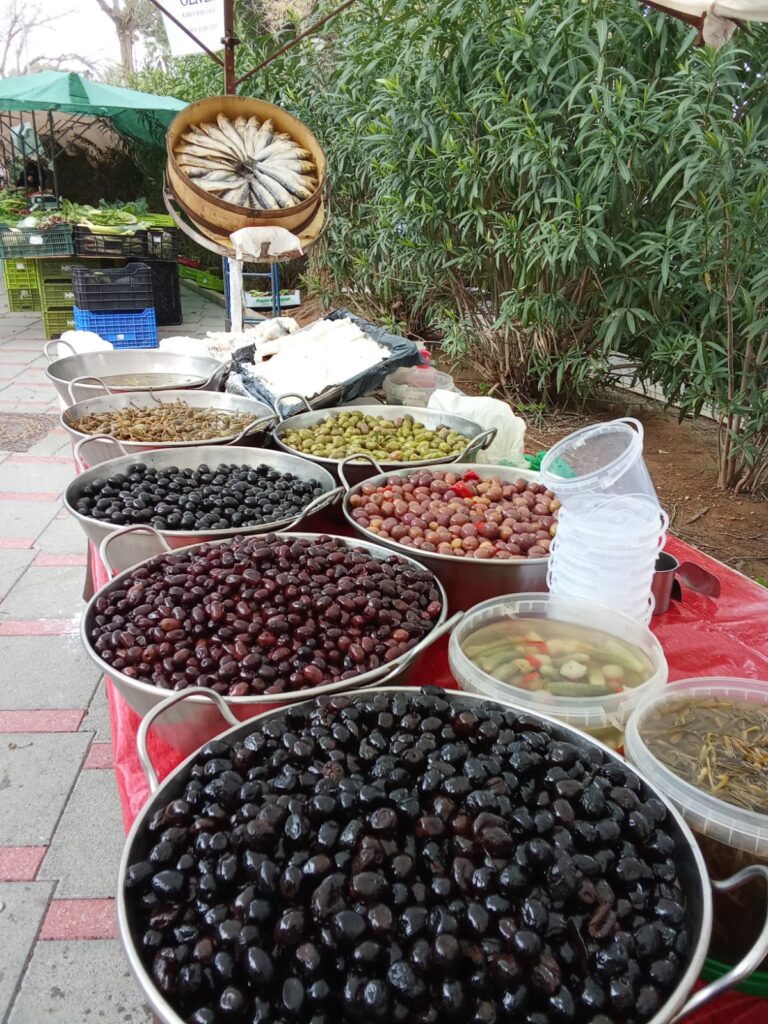 Large variety of olives, pickled vegetables, and preserved fish offered in bowls and tubs at the Weekly Market Paguera – a taste of Mediterranean tradition.