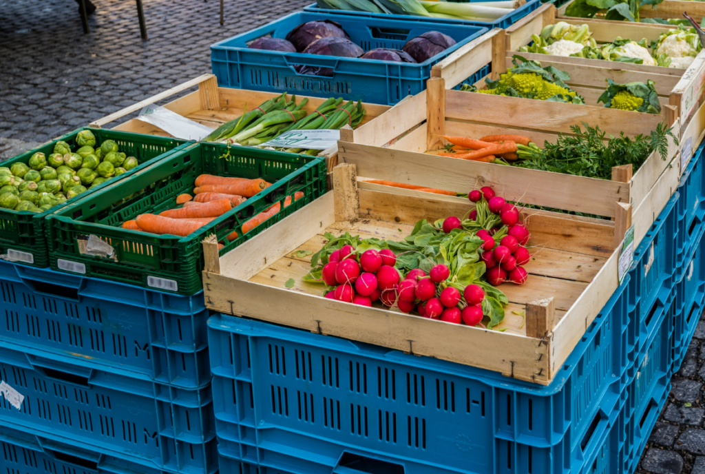 Fresh vegetables in wooden crates at a weekly market Porto Cristo in Mallorca – seasonal local harvest.