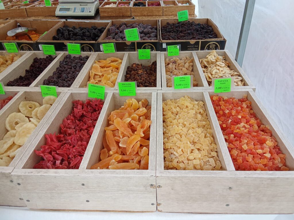 The weekly market Llucmajor, Mallorca, offers a vibrant mix of fresh local produce, traditional cured sausages, artisanal cheeses, handmade ceramics, and clothing stalls, set against the charming backdrop of the town’s historic streets and plazas.