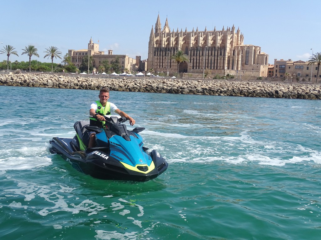 Jet ski adventure in front of La Seu Cathedral in Palma de Mallorca – thrilling water sport experience combining culture and adrenaline at Playa de Palma.

